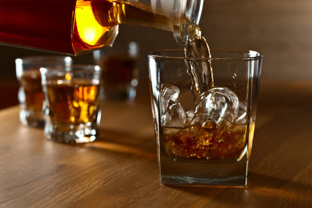 Whiskey with natural ice on a oak table.